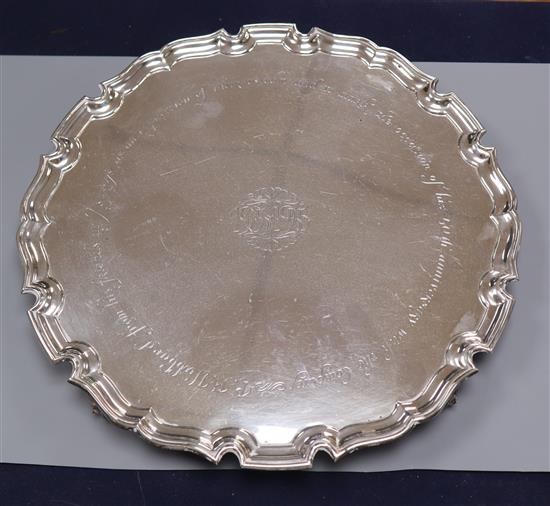 A circular silver salver, with piecrust edge and four scrolled feet, Edward Barnard & Sons, London 1942 32 oz.